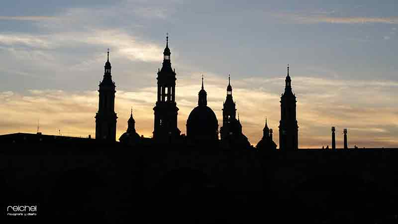 una panoramica de la basilica del pilar con siliuetas al atardecer